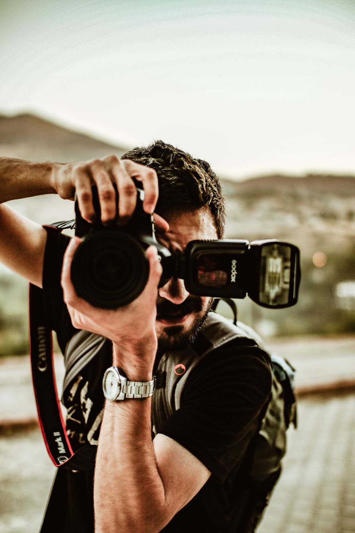 A photographer holding a camera outdoors