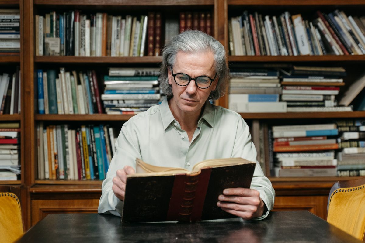 A reader with a book among library shelves